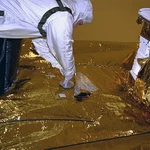 NASA/JPL-Caltech, A Jet Propulsion Laboratory technician inserts the DVD containing Kac's Monogram and many other files into a shallow cavity between two pieces of aluminum that protected it from micrometeoroid impacts.